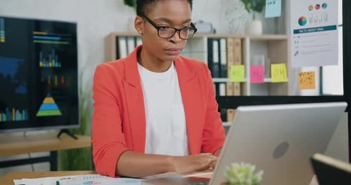 Focused Woman Working on Laptop in Modern Office