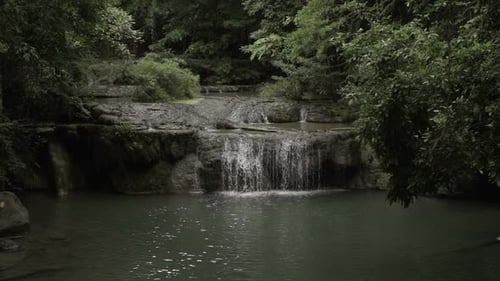 Waterfall Flowing into Tropical Pool in Nature