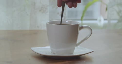Stirring a Hot Cup of Coffee with Spoon