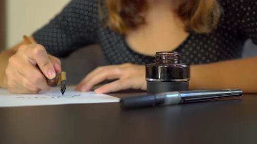 Close Up Shot of a Young Woman Calligraphy Writing on a Paper Using Lettering Technique