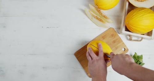 Les hommes coupent le melon mûr en deux à la main