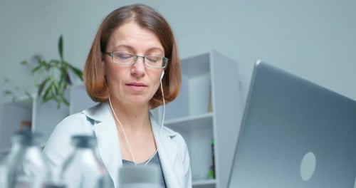 Woman Doctor Using Laptop in Office for Telemedicine