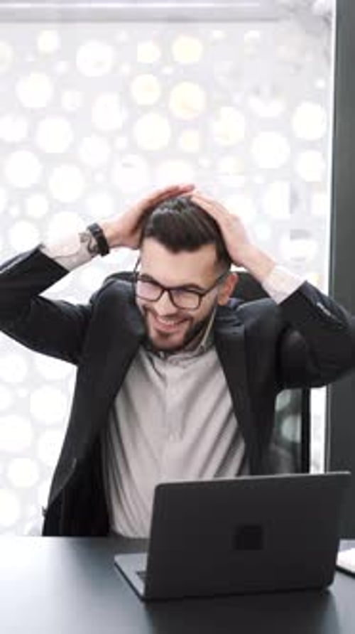 Handsome Young Man Working at Office Desk with Laptop