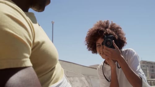 Woman taking photo of man with digital camera on the beach 4k