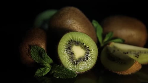 Delicious Juicy Fruit Kiwi and Mint Lie on a Black Table