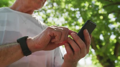 Senior man using smartphone in the park