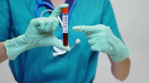 Ärztin Krankenschwester Frau mit Schutzmaske und Handschuhen - Durchführung eines COVID-19-positiven Bluttests