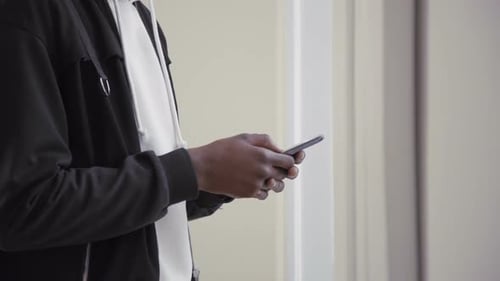 Hands of Young African American Man Using Smartphone