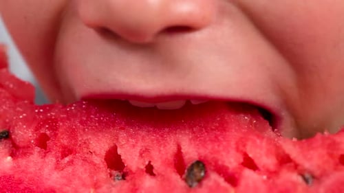 Child Eating a Slice of Juicy Red Watermelon