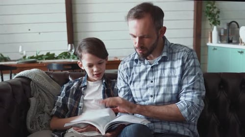 Father and Son Reading Book Together at Home