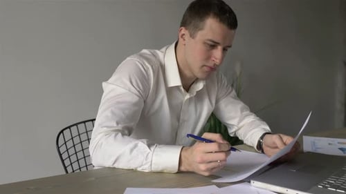 businessman makes notes in documents while sitting in the office
