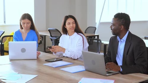 Office Workers at Conference Table Using Technology