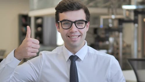 Smiling Man Giving Thumbs Up in Office Setting