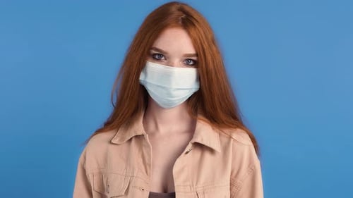 Woman in Mask Gives Thumbs Down on Blue