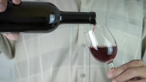 Ein Mann gießt Wein ein.