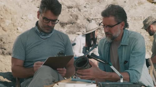 Male Archaeologists Examining Ancient Vase