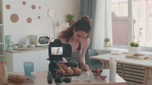 Woman Frosting Muffins in Kitchen for Vlog