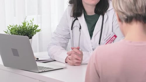Female Patient and Woman Doctor Talking in Clinic Office During Appointment