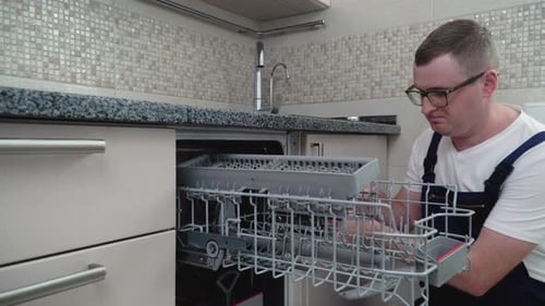 Mechaniker repariert Geschirrspüler in der Küche