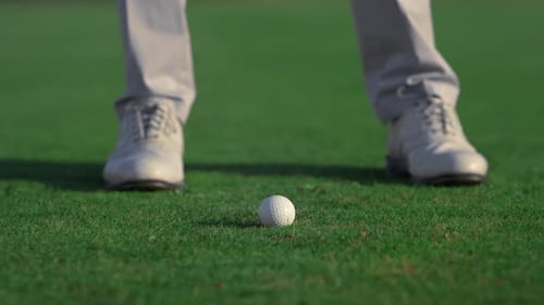 Man Legs Swinging Golf Putter Club on Course Field