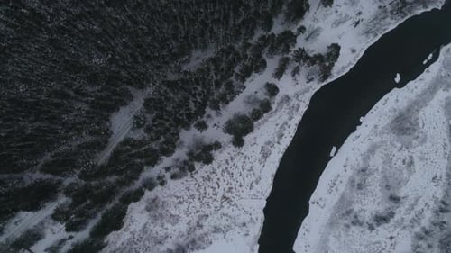 Vue aérienne de la rivière d'hiver près de la forêt et des champs, généralement nuageux