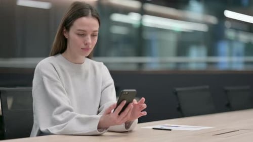 Woman Using Mobile Phone at Office Table