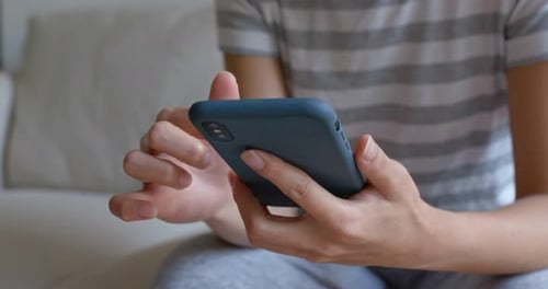 Person Using Smart Phone Touchscreen at Home