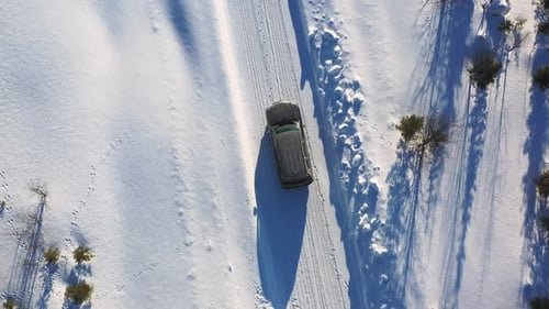 Aerial Shot of SUV Driving on Snowy Road