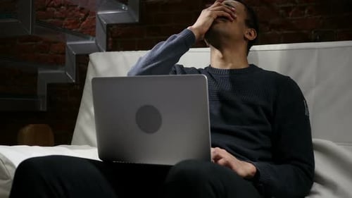 Young Adult Frustrated Using Laptop Indoors