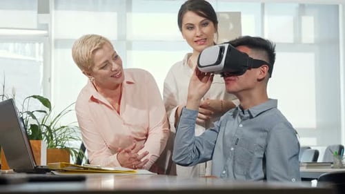 Young Man Using VR Headset with Colleagues in Office