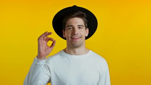 Smiling Man Gives OK Gesture on Yellow