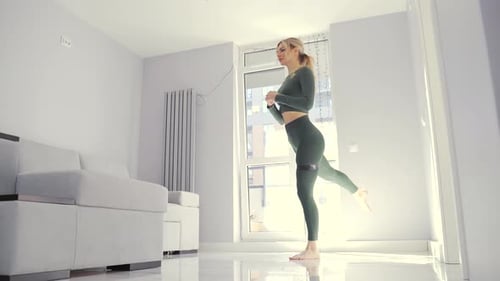 Blonde Woman Exercising with Resistance Band at Home