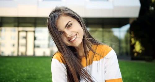Smiling Woman with Long Brown Hair Outside