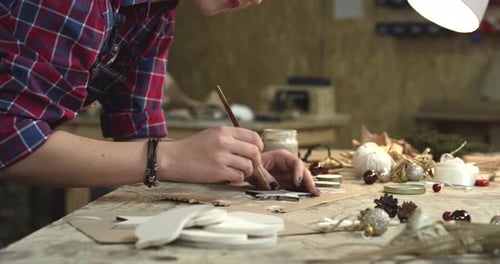 Young Hipster Painting Handmade Goods in her Studio