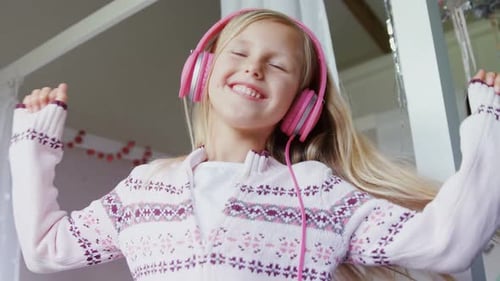 Cheerful Girl Dances With Headphones in Bedroom