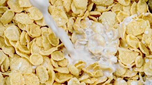 Milk Being Poured onto Cornflakes in Close Up