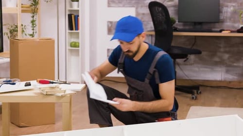 Ouvrier d'assemblage de meubles confus pendant la lecture