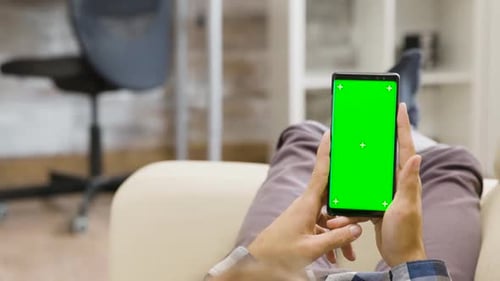 Parallax Shot of Man Holding a Green Screen Phone in His Hands