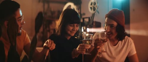 Friends Toasting and Celebrating Friendship Indoors at Night