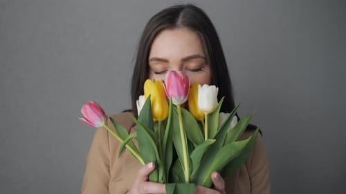 Woman Enjoys Fresh Tulips Bouquet Indoors