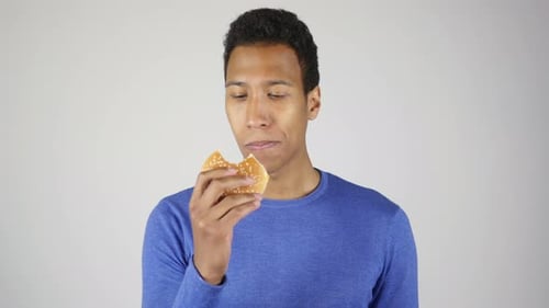 Young Adult Eating a Hamburger in Studio