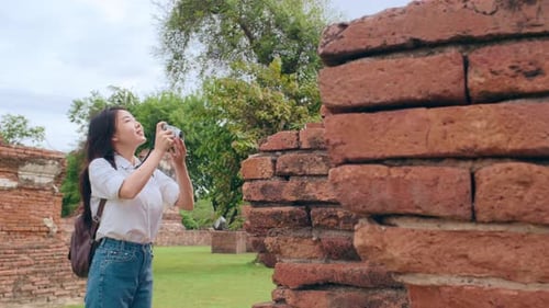 Asian woman using camera for take a picture while spending holiday trip at Ayutthaya.