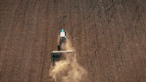 Aerial View Modern Red Tractor on the Agricultural Field on Sunset Time. Tractor Plowing Land and