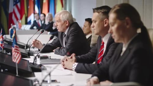 Executives Delivering a Speech at a Conference Table
