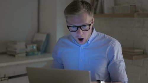Geschäftsmann wird schockiert, während er am Laptop arbeitet