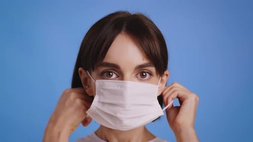 Young Woman Puts on a Face Mask