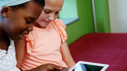 Schoolgirls using digital tablet