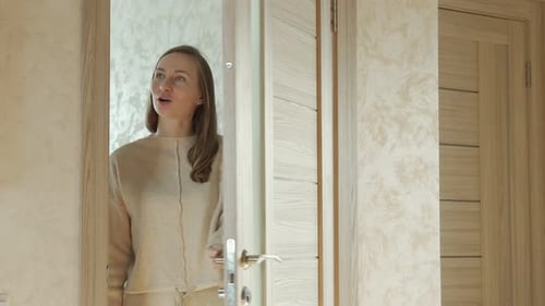 Woman Opens Doorway and Smiles