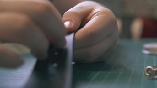 Hands Adding Metal Rivets to Leather Strap