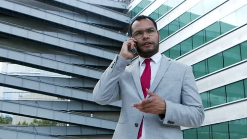 Confident Businessman on Cell Phone Outside Building